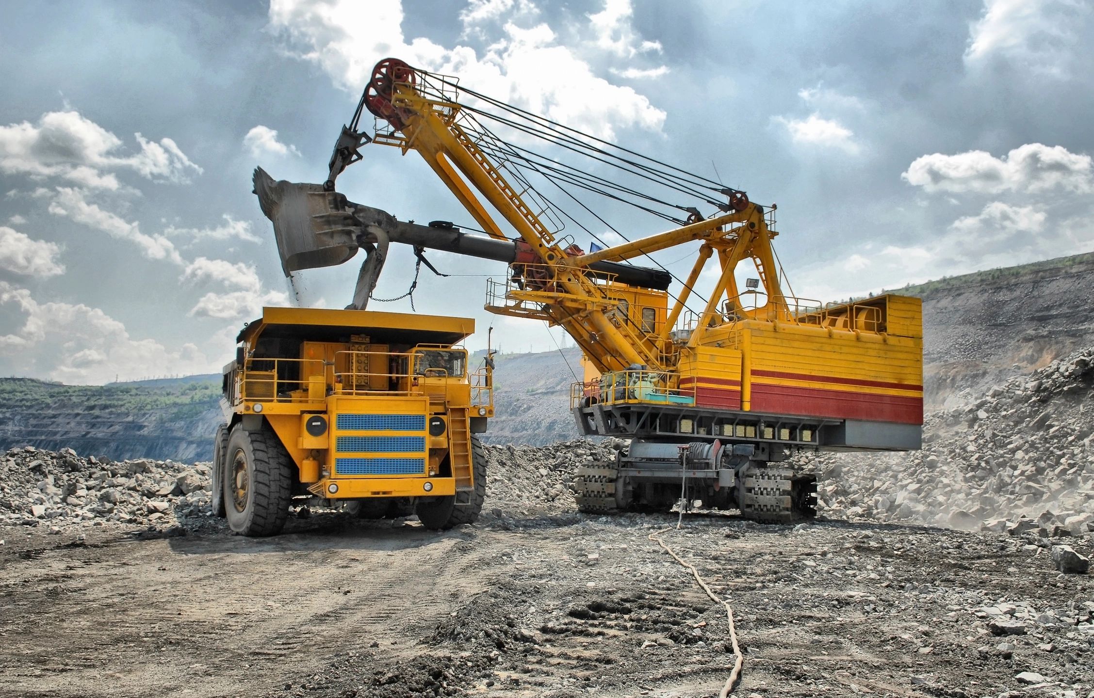 Modern mining vehicles extracting resources at a mine site.